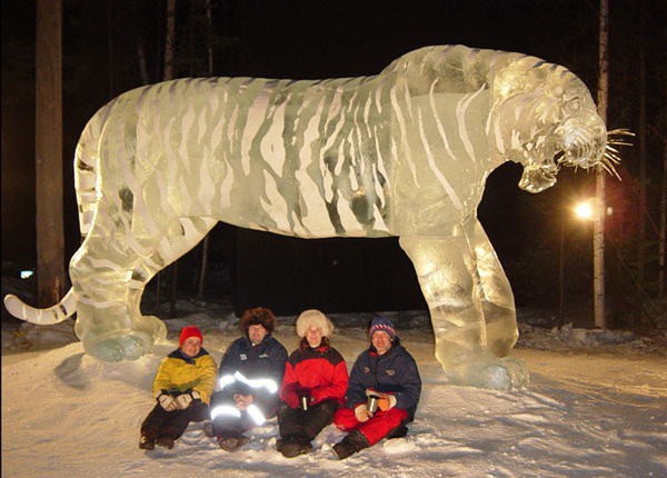 Brice and Brown ice sculpture_"A Rabbit’s View” at night with the artists sitting in the snow.
