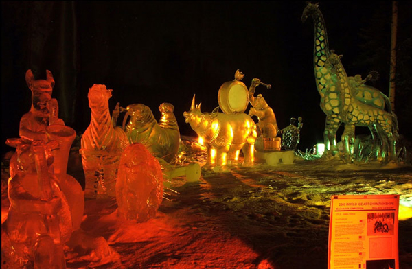 Animal Parade ice sculpture, lit with colored lights, at night. By Steve Brice, Heather Brown, Tjana Raukar, and Mario Amegee. Ice Alaska 2005.