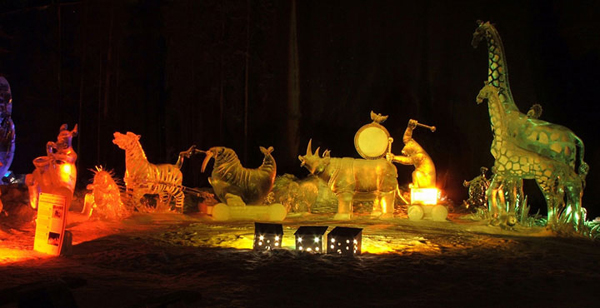 Animal Parade ice sculpture, many animals, rhino, giraff, walrus, zebra, gorilla...at night lit with colored lights. By Steve Brice, Heather Brown, Tjana Raukar, and Mario Amegee. Ice Alaska 2005.