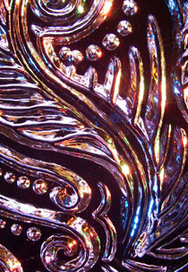 Detail of swirls and feathery pattern carved into ice, lit by colored lights, by Aaron Costic. Photo: Aaron Costic.