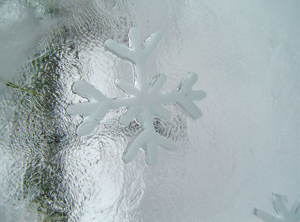 “Kai Tormikoski sculpture "Four Seasons" 4 ice panels with simple elements of weather carved into them, representing the seasons. Kalajoki, Finland 2004. Here is a detail of the panel with the snowflakes. Detail image of the texture of the ice and snowflake element packed with snow.