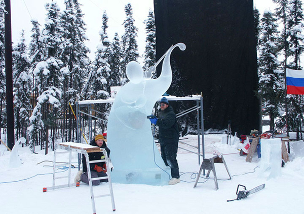 Fiddler in progress, artists on scaffolding, daylight, black cloth hung in trees to block the sun. Vladimir Zhikhartsev and Vitaliy Lednev artists at work.